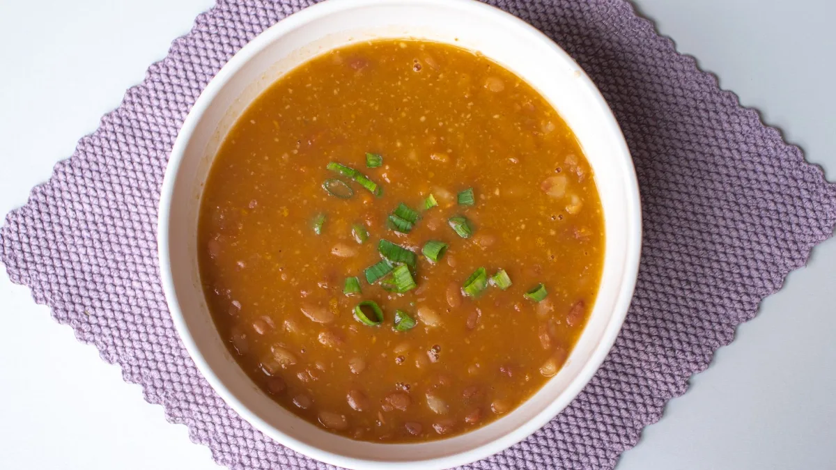 Bowl of homemade bean soup topped with fresh herbs