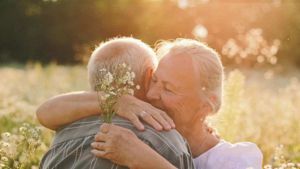 Older couple embracing outdoors in warm evening light