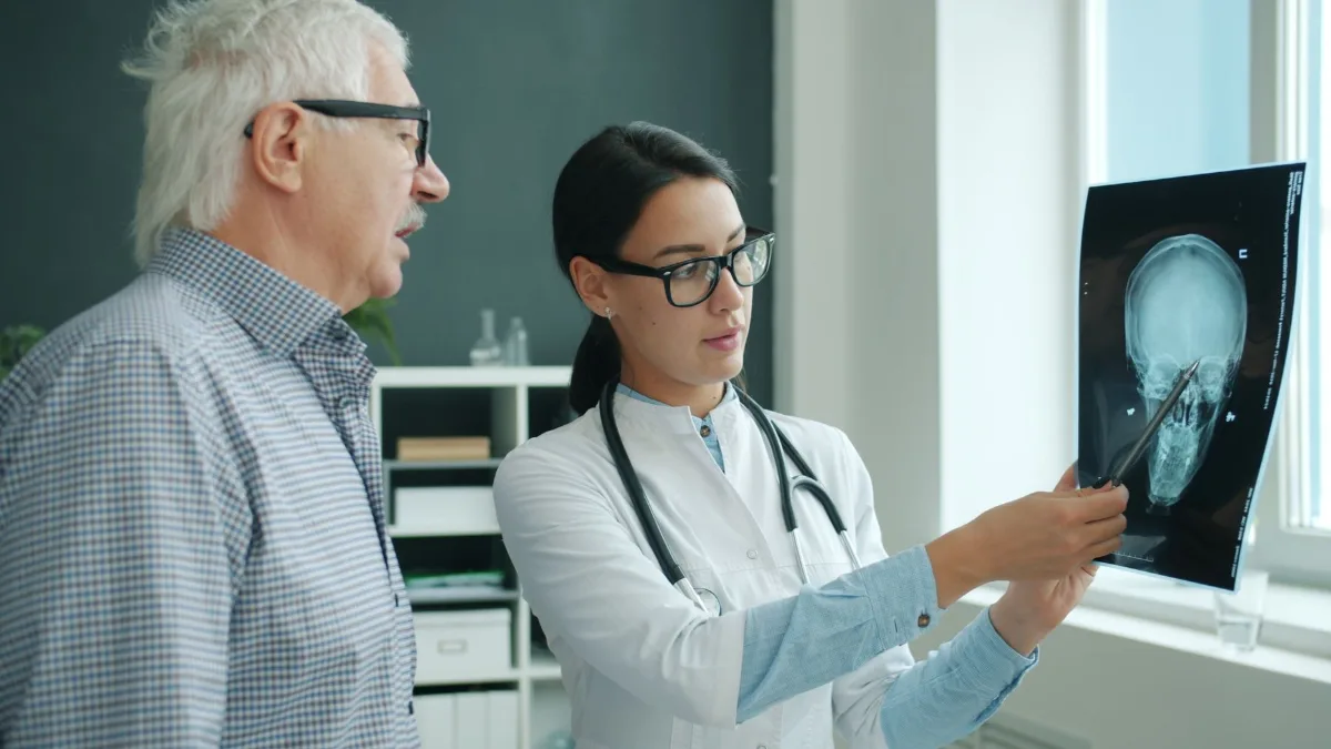 Doctor showing an x-ray to an older male patient