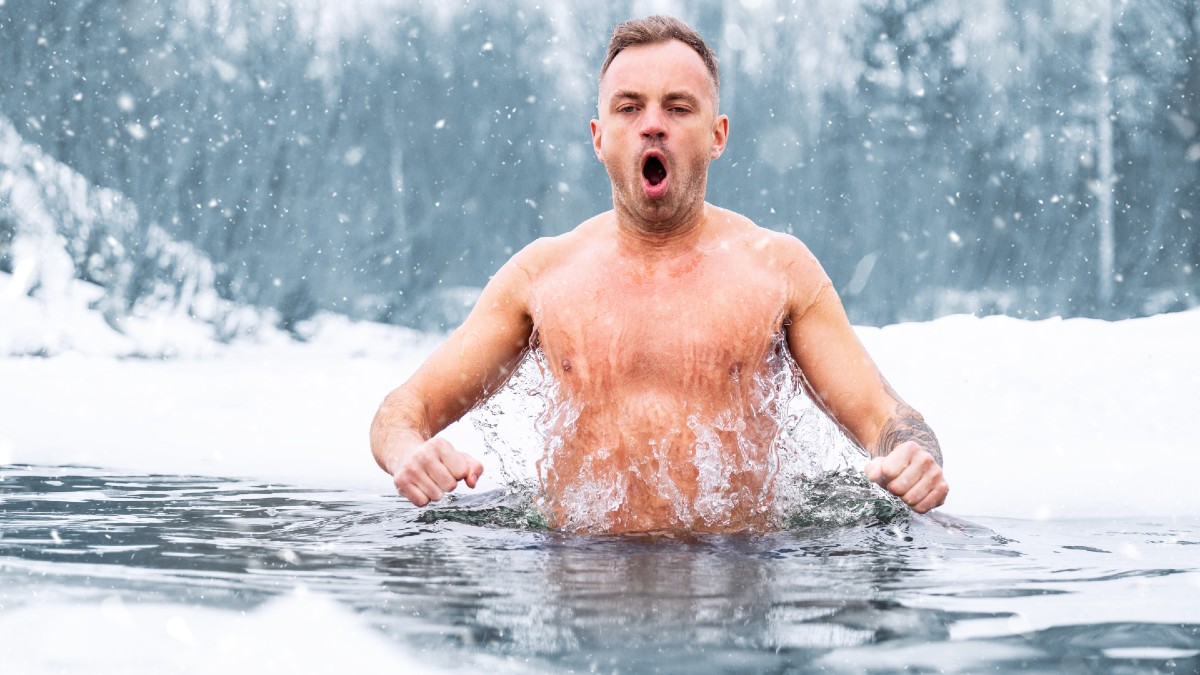 man jumping cold water winter
