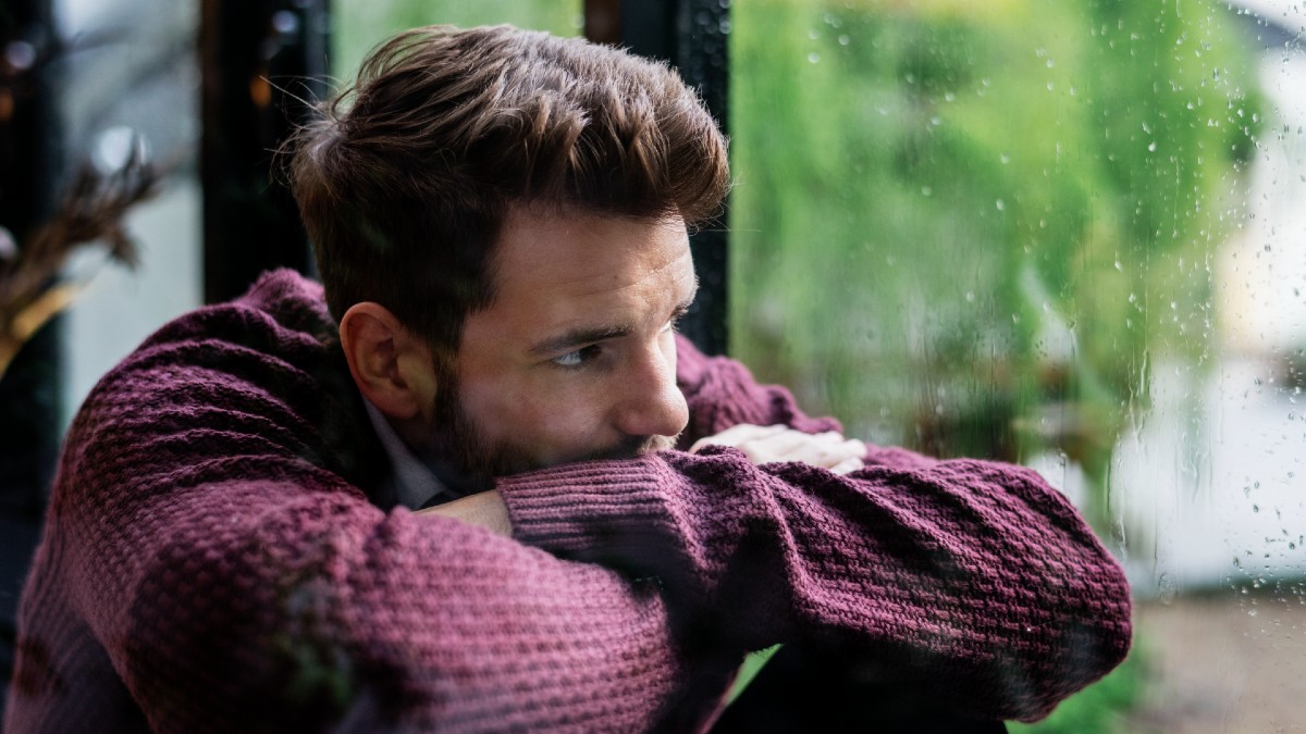 man looking out window