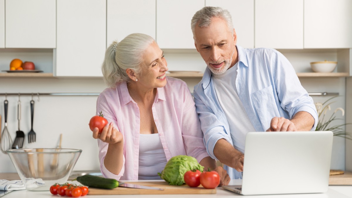 mature couple family using laptop while cooking