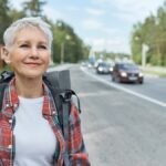 woman carrying backpack walking along-high road